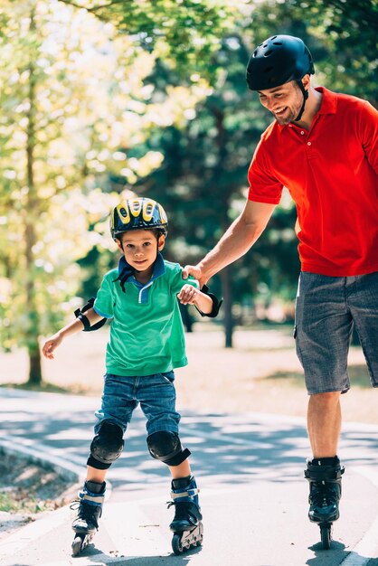 Father and son roller skating in park