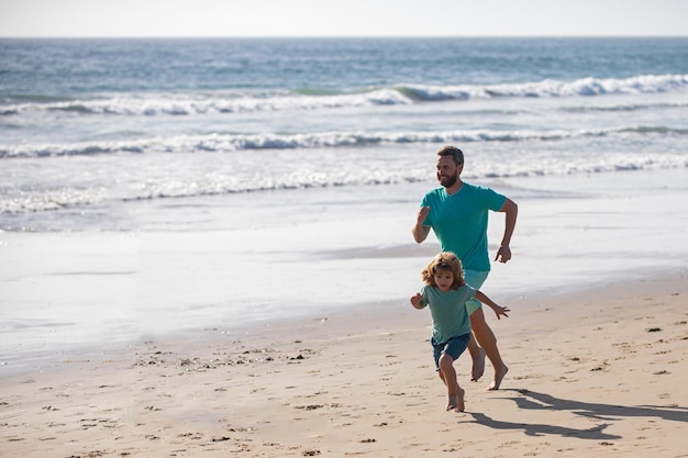 Padre e figlio che corrono sulla spiaggia. sport e stile di vita sano, jogging in famiglia sulla spiaggia.