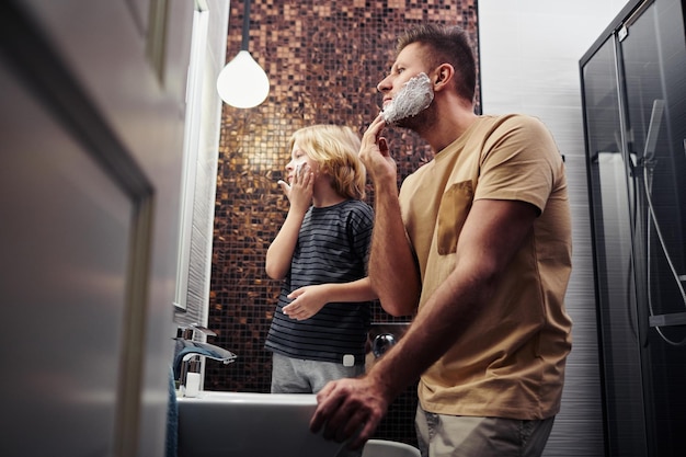 Father and son shaving in bathroom