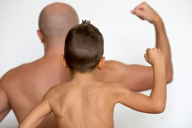 Foto padre e figlio mostrano i muscoli