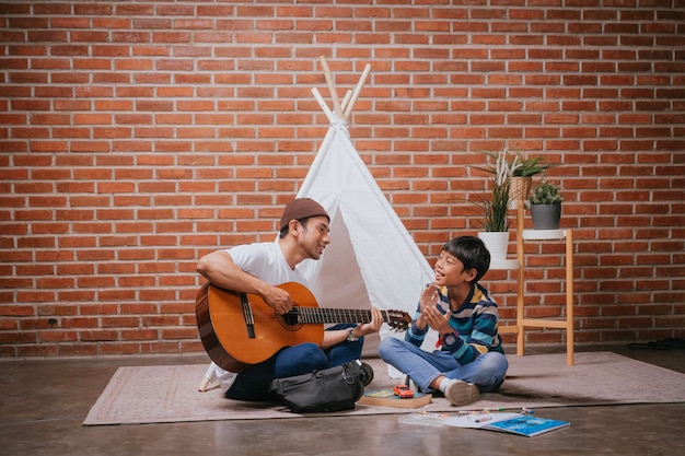 Photo father and son singing together at home