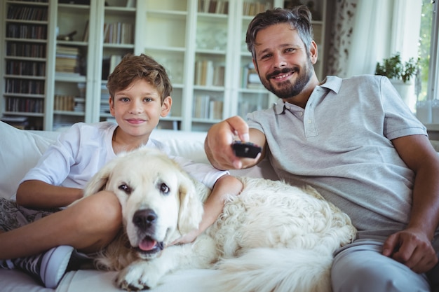 父と息子の愛犬とソファに座ってテレビを見て