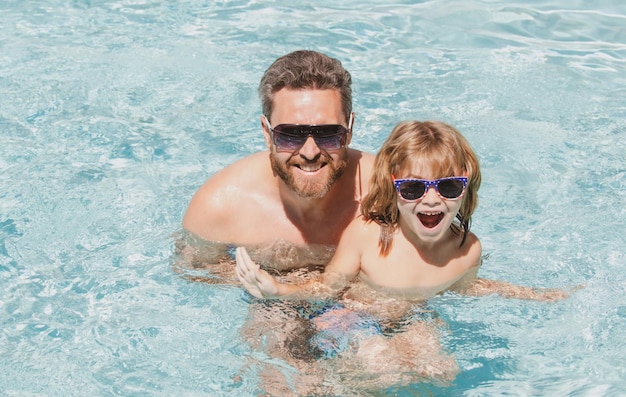 プールで泳ぐ父と息子夏の家族夏の週末の水泳レッスンでプールで幸せな家族