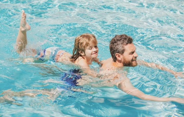 Father and son swimming in pool summer family holidays dad and son in pool swimming lessons fathers