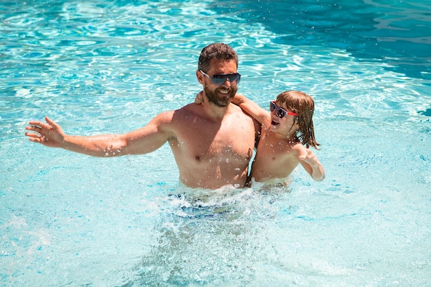 Father and son swimming in pool summer family weekeng