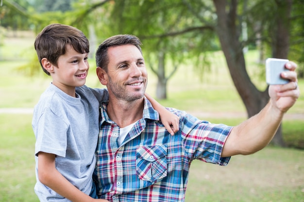 Father and son taking a selfie in the park