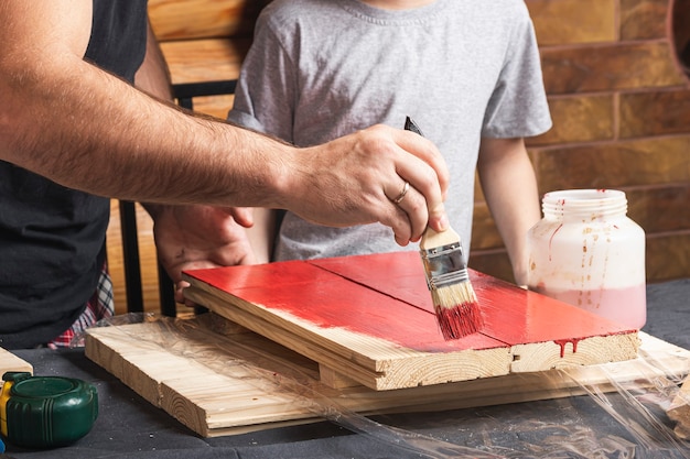 Father and son together make a wooden birdhouse in the workshop