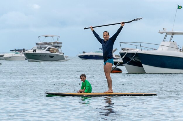 Padre e figlio insieme su una tavola da paddle