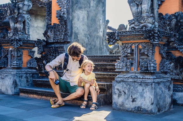 Tanah Lot - Temple in the Ocean의 배경에 있는 아버지와 아들 관광객. 인도네시아 발리. 어린이 개념과 함께 여행