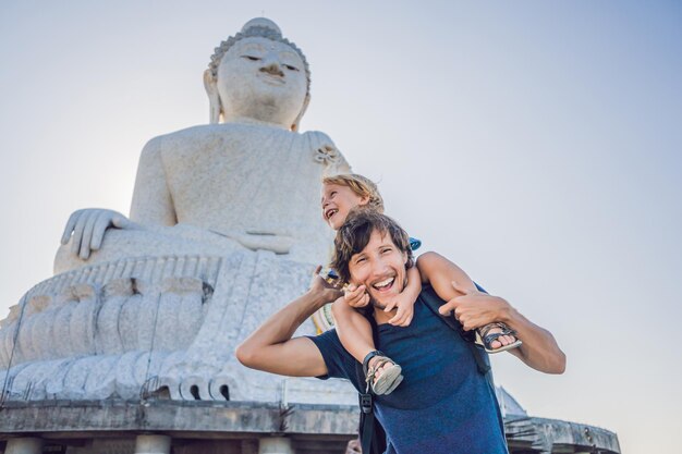 Father and son tourists on the Big Buddha statue. Was built on a high hilltop of Phuket Thailand Can be seen from a distance. Traveling with children concept.