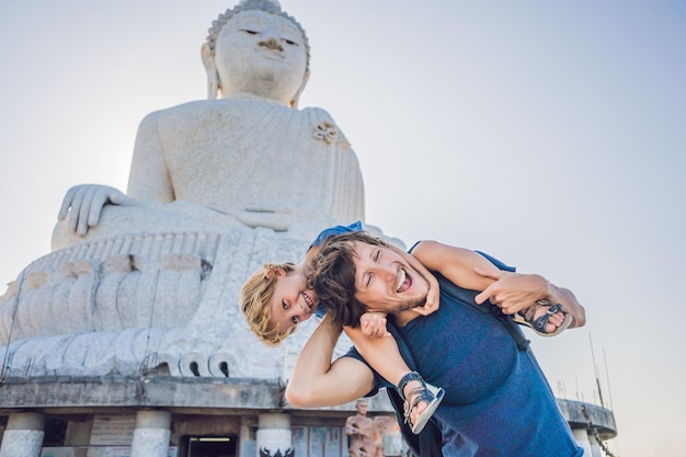 Father and son tourists on the Big Buddha statue. Was built on a high hilltop of Phuket Thailand Can be seen from a distance. Traveling with children concept.