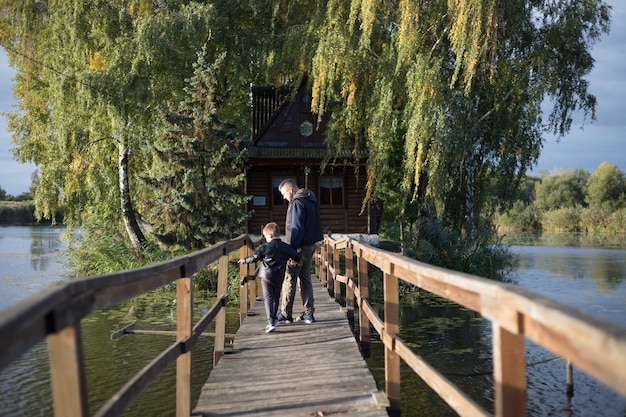 Father and son tourists on Old bridge Attraction Long extreme wooden bridge across the river