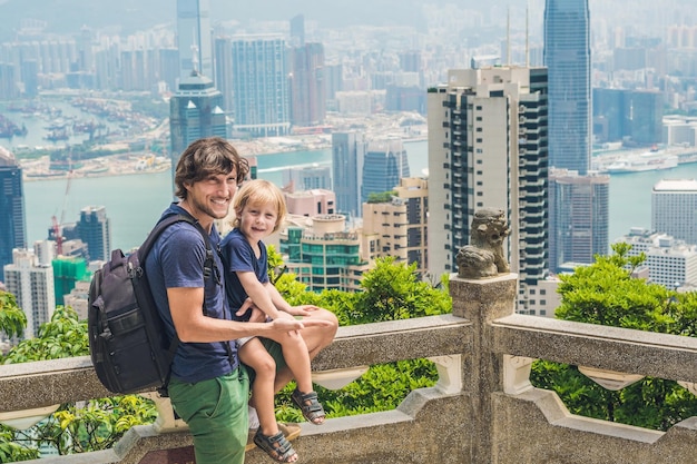 Father and son travelers at the peak of Victoria against the backdrop of Hong Kong. Traveling with children concept