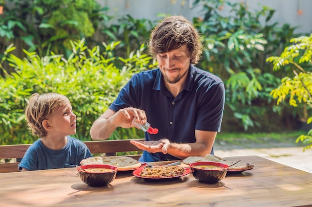 Father and son using wash hand sanitizer gel before eating in a cafe