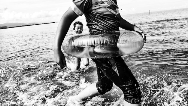 Photo father and son wading in sea