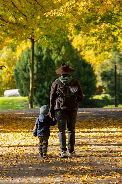 Father and son walk in the park in autumn