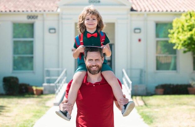 Foto padre e figlio che camminano nel parco scolastico concetto di famiglia amichevole