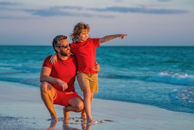 Father and son walking together on the beach fatherhood family concept travel on sea with father rel