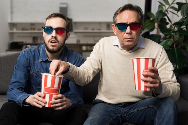 Foto padre e figlio che guardano film 3d in salone