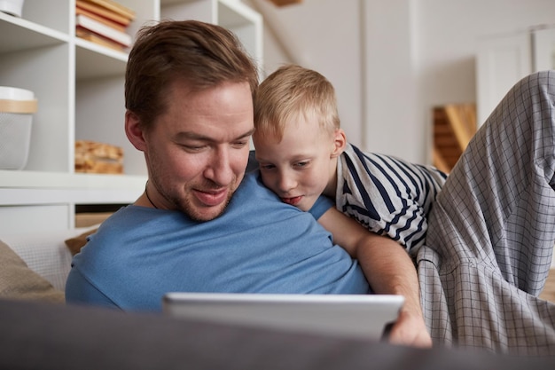 Father and son watching photos on tablet