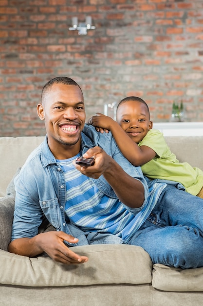 Father and son watching tv together on the couch