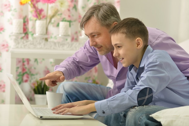 Father and son with laptop at the table