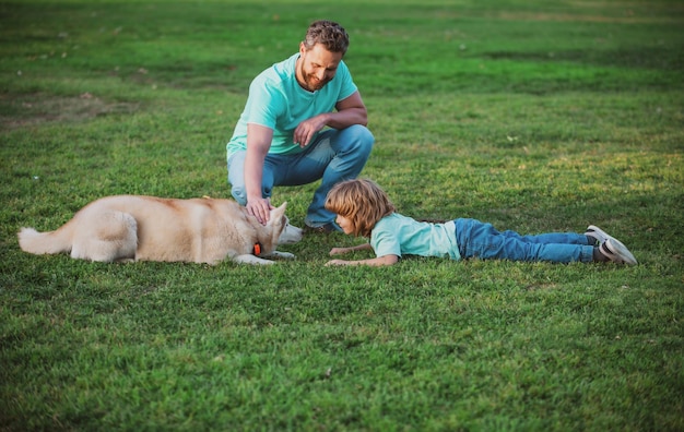 Father and son with pet dog on nature