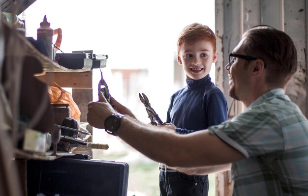 Father and son work together in the home workshopthe concept of fatherhood