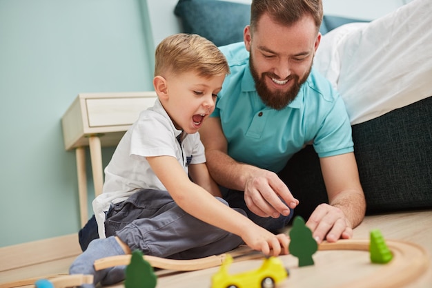 Photo father and song playing with toys at home