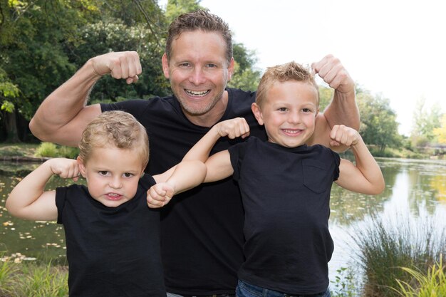 Father and sons shows his biceps for play in fun in vacation