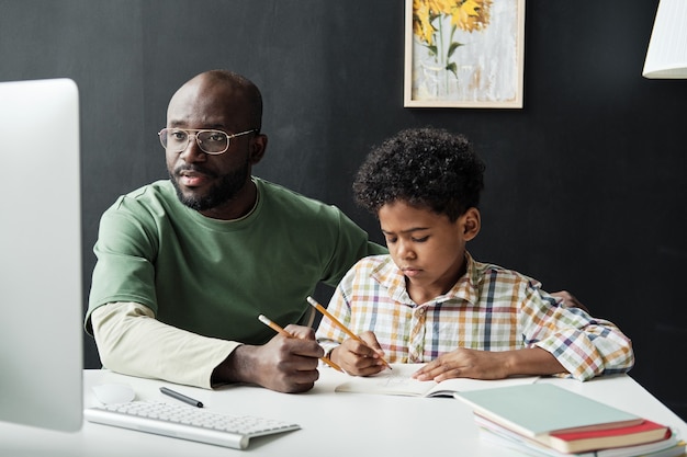 Foto padre che studia con suo figlio a casa