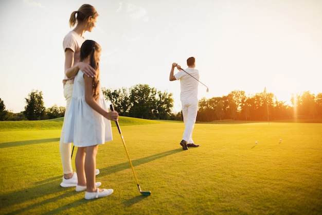 Father takes golf shot famiglia felice di giocatori.