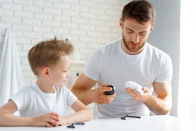 Father teaches his little son how to shave face