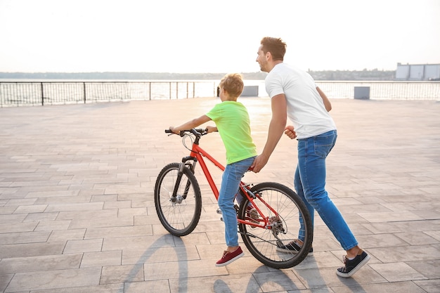 Father teaching his son to ride bicycle outdoors