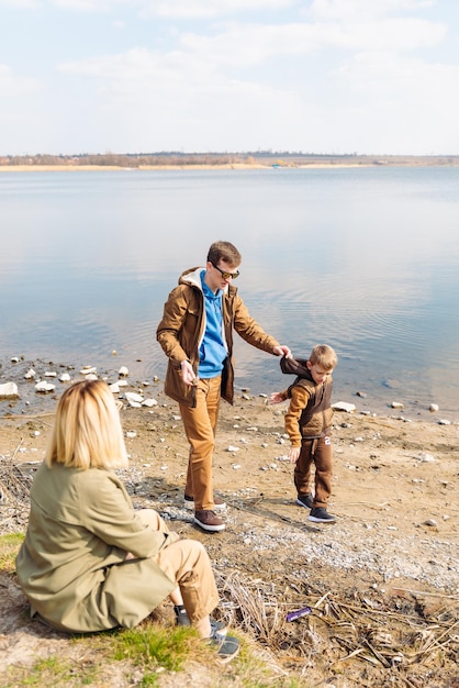 Father teaching little son throw rocks in water