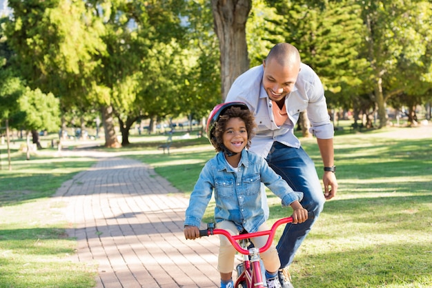 Padre che insegna al figlio in bicicletta