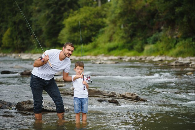 Father teaching son how to fish in the river