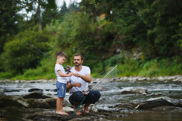 Father teaching son how to fish in the river