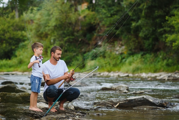 Father teaching son how to fish in the river