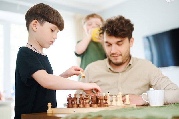 Father teaching son how to play chess