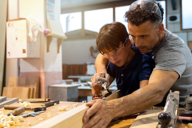 Father teaching son how to work with wood in a carpentry. 