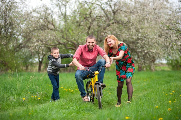 Father teaching son to ride a bike by his example