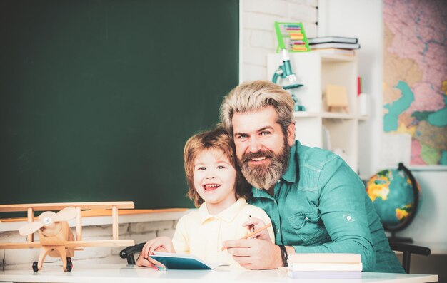 Foto padre che insegna al figlio, partenariato della comunità scolastica, i bambini delle scuole felici a lezione, il bambino e l'insegnante sono lear