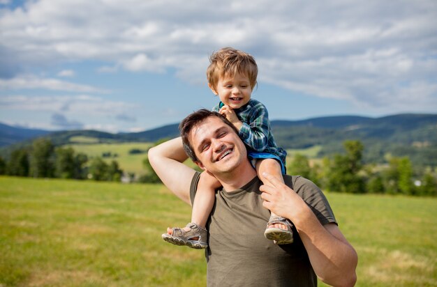 Father and toddler boy have a fun in a mountains