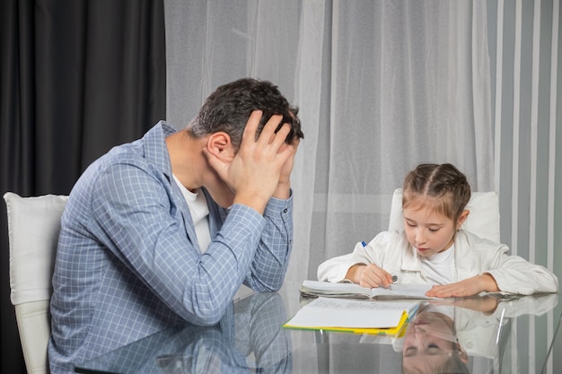 Il padre cerca di aiutare la figlia con i compiti a casa e si stanca