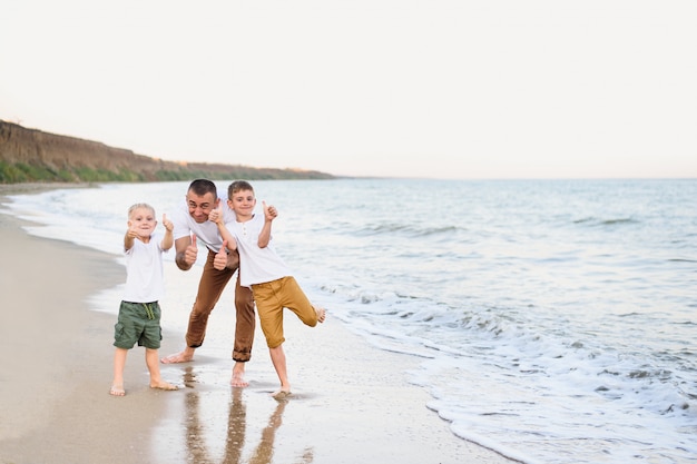 Father and two sons show class, sea coast. Enjoying vacation