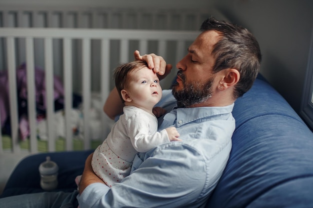 Photo father with baby sitting at home