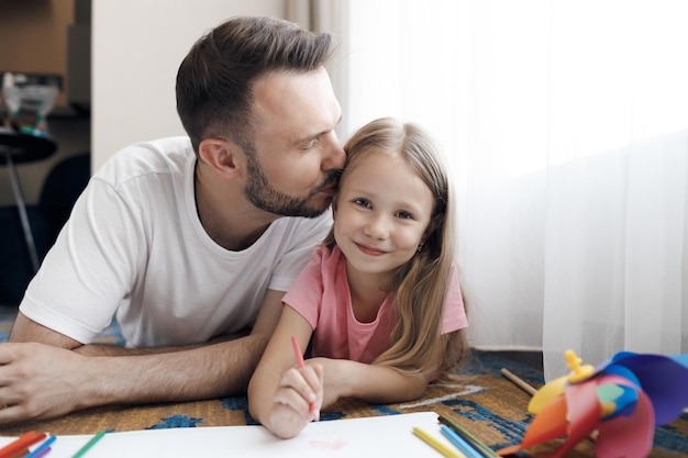 Photo father with cute little daughter drawing at home