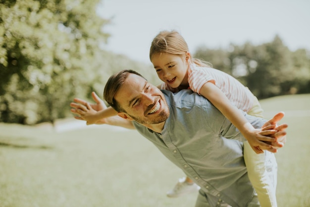 Photo father with cute little daughter having fun at the park