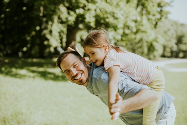 Father with cute little daughter having fun at the park